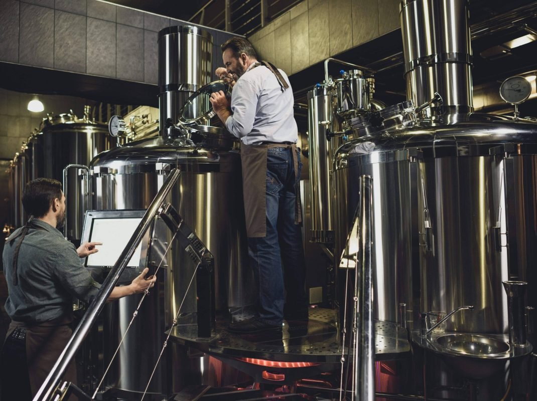 male-brewers-in-aprons-working-with-tanks-and-indu-2024-11-19-17-22-08-utc